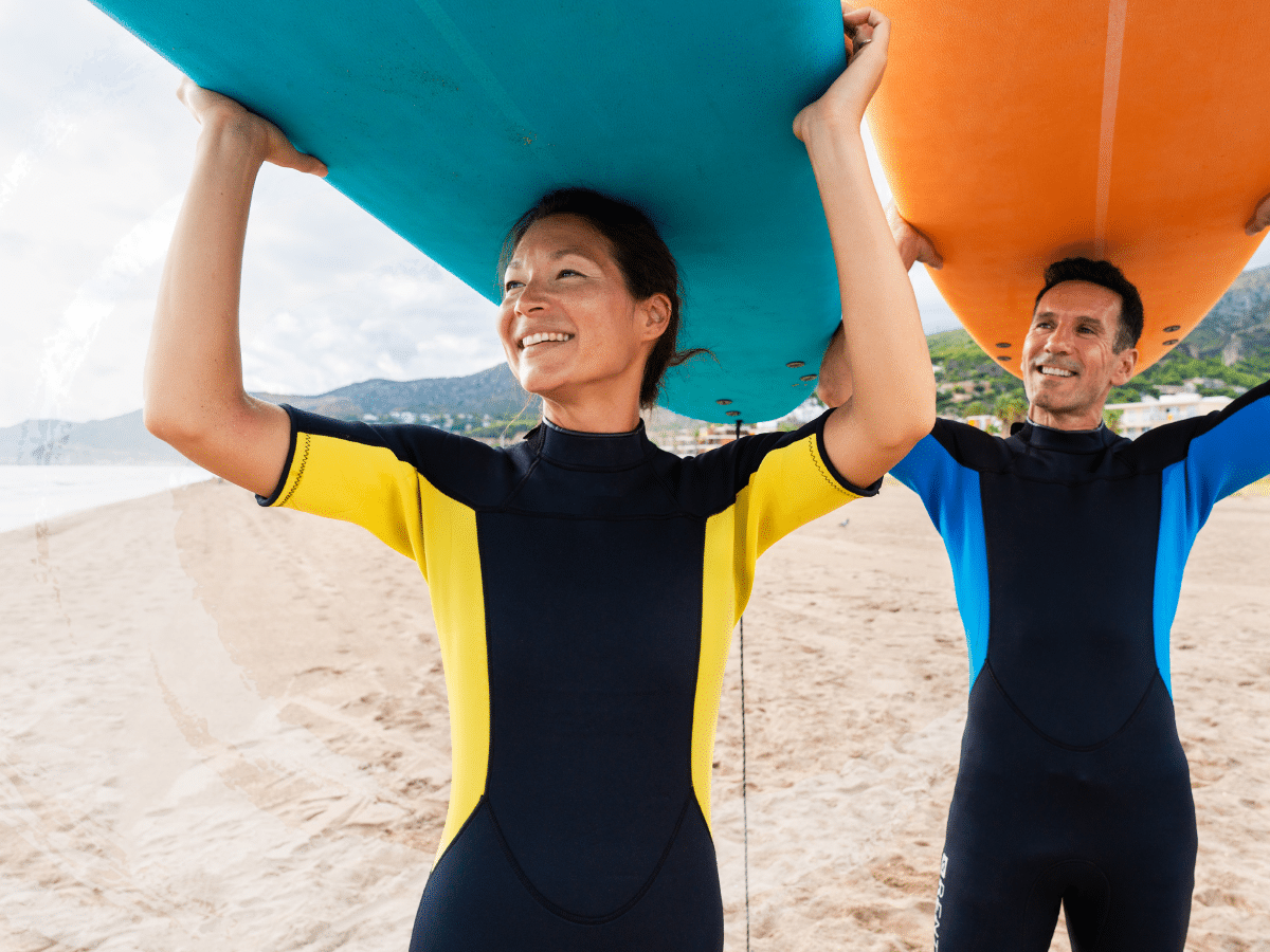 Two people carrying surfboards above their heads, symbolizing how does spravato work in the brain