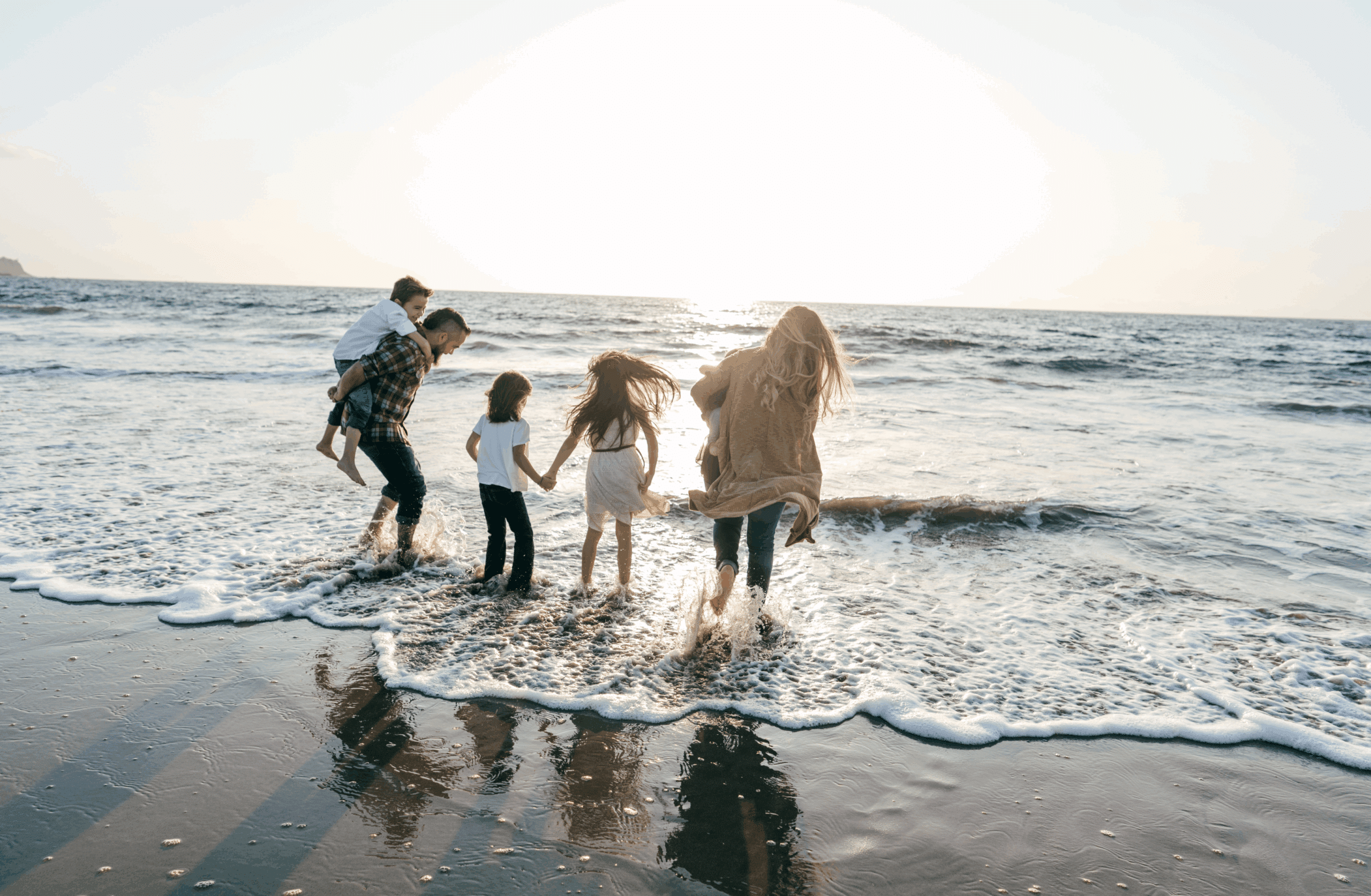 A family playing in the waves at the beach, symbolizing how Spravato can help treat suicidal thoughts