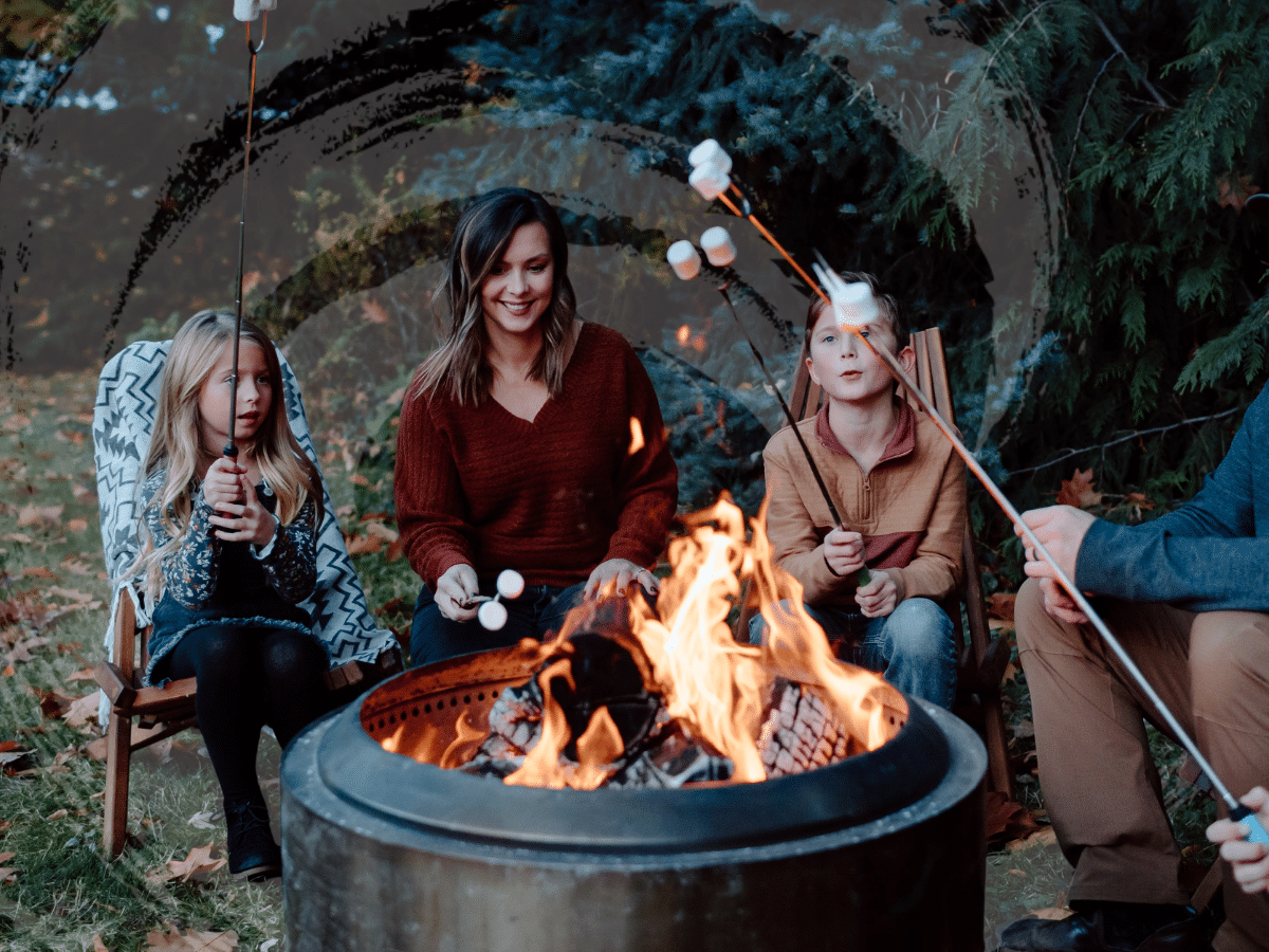 A family gathered around the campfire roasting marshmallows, symbolizing Spravato side effects