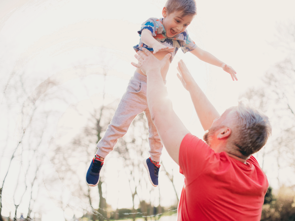 A man throwing a child into the air, symbolizing TMS for chronic pain.