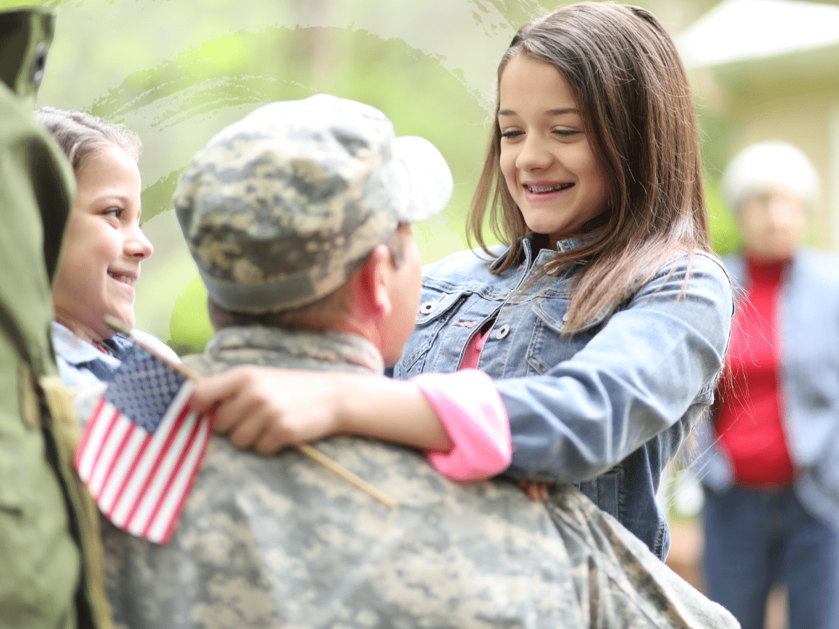 A veteran holding two girls, symbolizing mental health in veterans