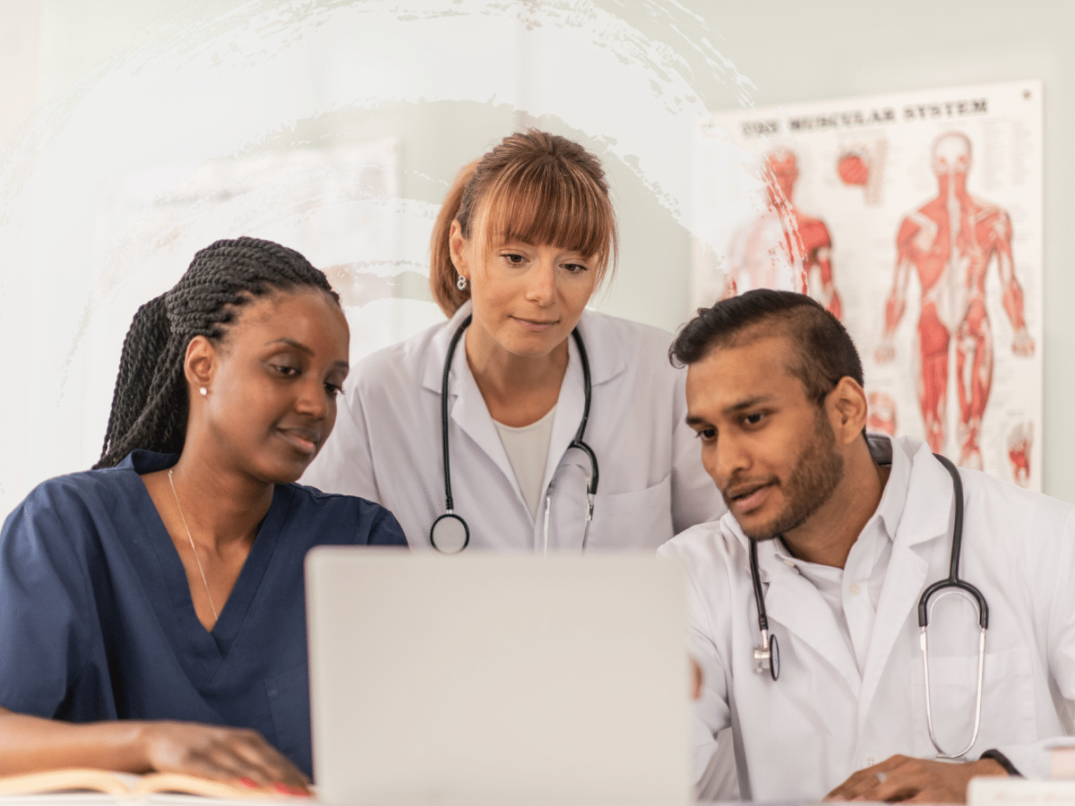 Three medical professionals discussing something over a computer, symbolizing pharmacogenomic testing